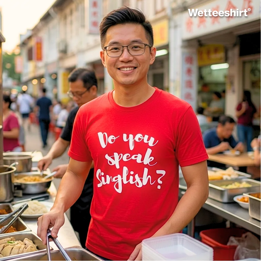 "Man at Singapore street food stall wearing bright red ‘Do you speak Singlish?’ graphic T-shirt, casual unisex streetwear by Wetteeshirt, premium cotton tee celebrating local culture, Singlish slang fashion statement, trendy urban outfit for men and women.