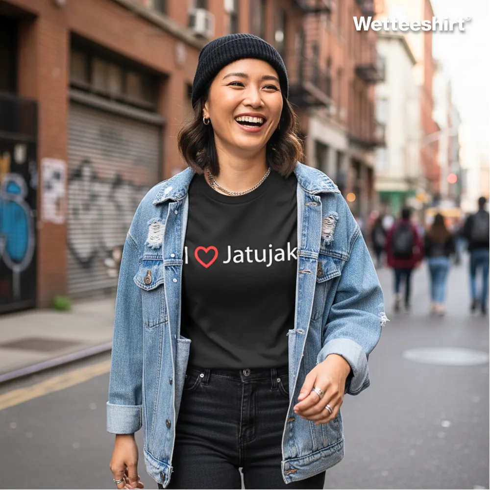 Black casual T-shirt with bold white ‘I ❤️ Jatujak’ slogan, styled with black beanie, denim jacket, and black jeans, worn while smiling on busy city street with graffiti walls and pedestrians — trendy streetwear celebrating Bangkok’s Chatuchak Weekend Market.