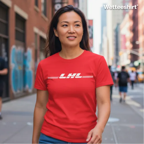 Red casual T-shirt with bold white ‘LHL’ slogan in stylized font, worn while walking down lively city street with graffiti walls, urban buildings, and pedestrians — modern streetwear fashion blending bold design with urban lifestyle.