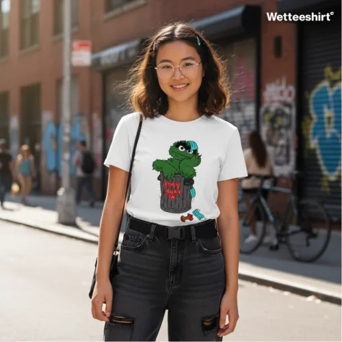 Unisex white short sleeve T-shirt with cartoon trash can character and bold “Stay Trashy” slogan, playful Singapore streetwear by Wet Tee Shirt®