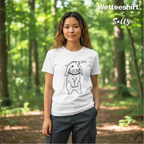 Singapore streetwear — person in forest wearing Wetteeshirt® x Salty white graphic t-shirt featuring simple cartoon bunny holding ‘meh’ sign in monochrome black line art, casual lifestyle fashion shot with tall trees and greenery.