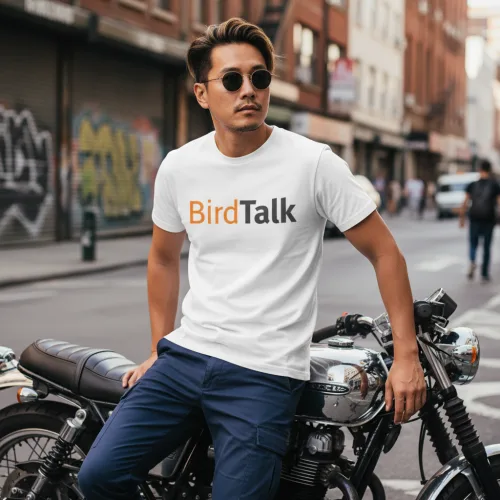 Singapore streetwear BirdTalk white short sleeve T-shirt, bold orange and black text design, casual unisex tee by Uncle Ahn T, premium cotton playful design photographed outdoors in urban motorcycle street setting